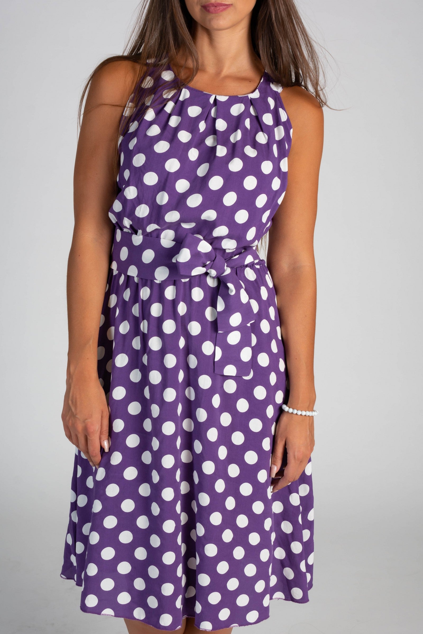 Lilac midi dress with a playful dot print, featuring a round collar, sleeveless design, and a decorative waist tie.