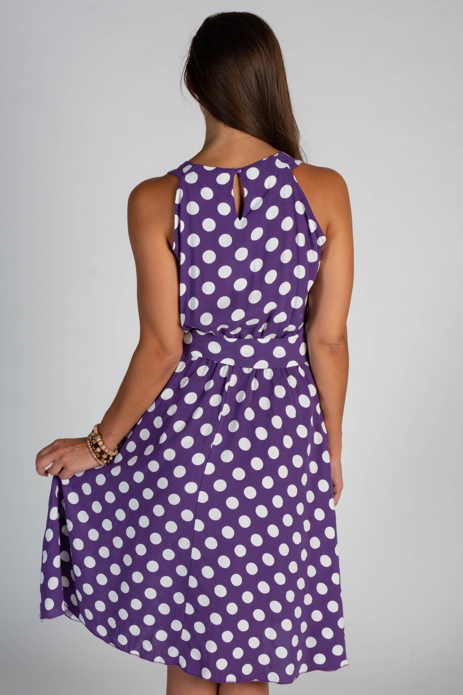 Lilac midi dress with a playful dot print, featuring a round collar, sleeveless design, and a decorative waist tie.