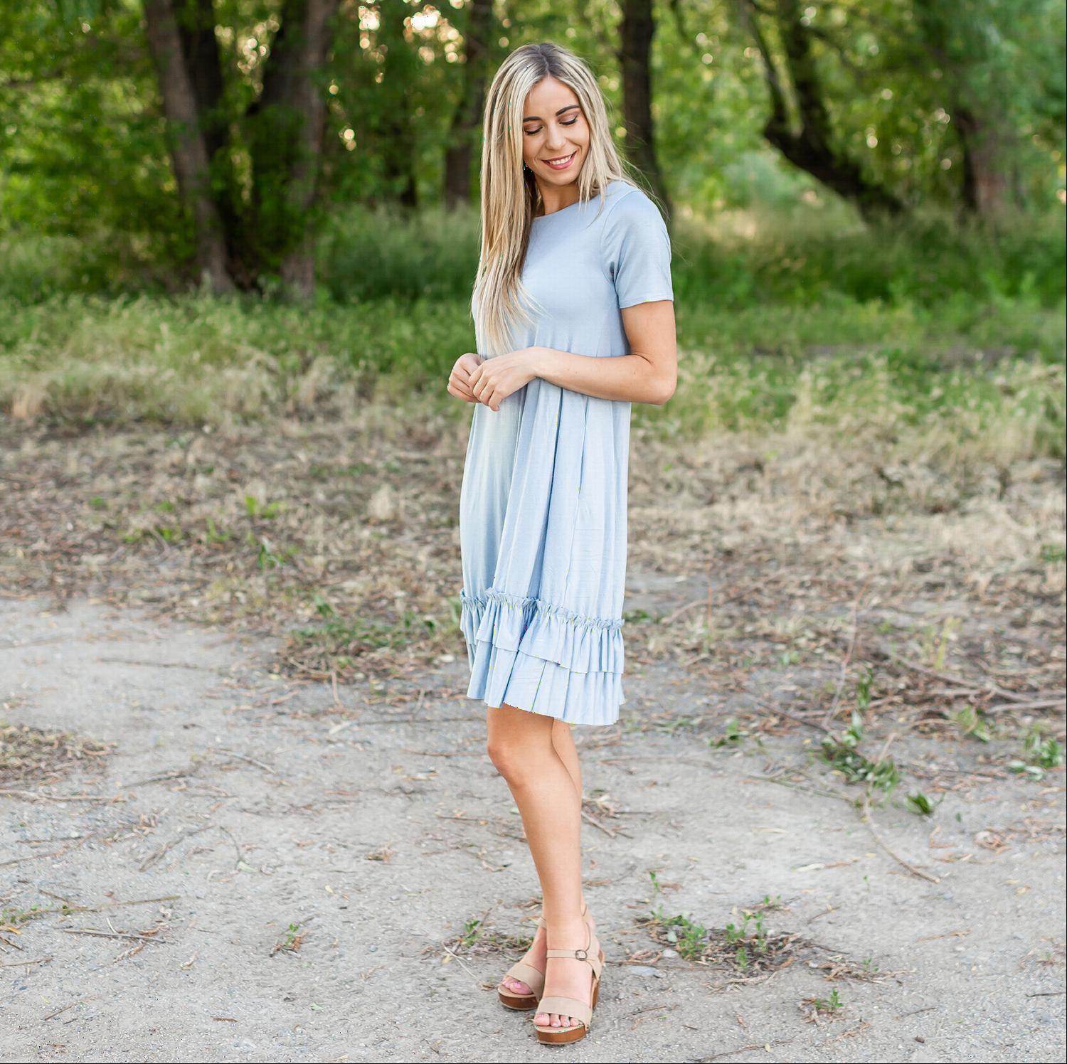 A stylish midi dress featuring short sleeves, cute pocket embellishments, and a ruffled hemline, perfect for any occasion.