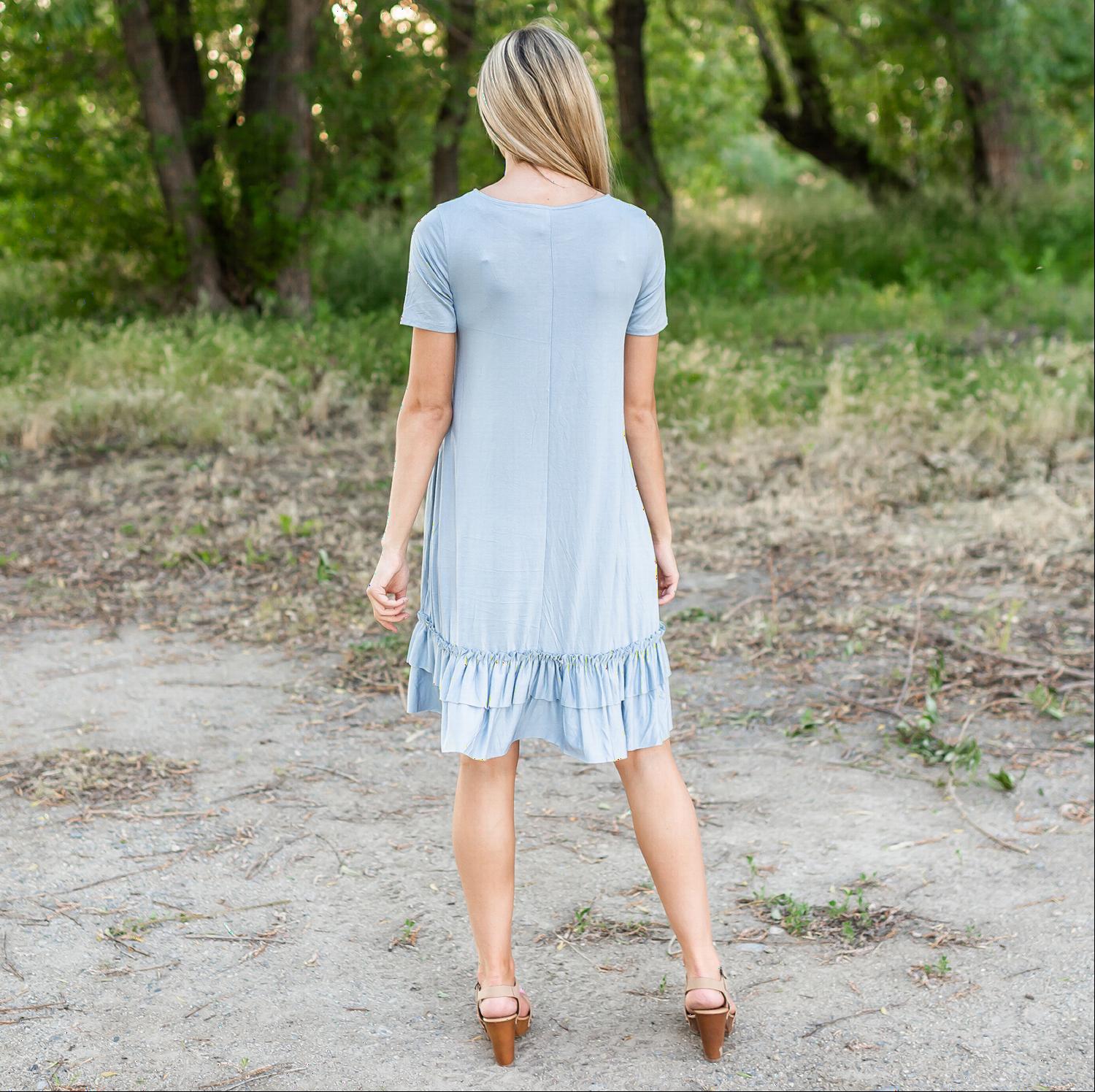 A stylish midi dress featuring short sleeves, cute pocket embellishments, and a ruffled hemline, perfect for any occasion.