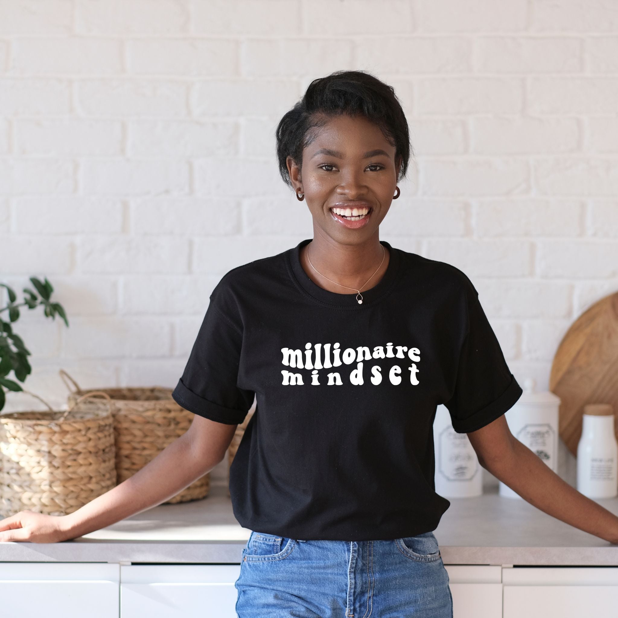 A stylish black t-shirt with the text 'Millionaire Mindset' printed on it, designed for women who aspire for success.