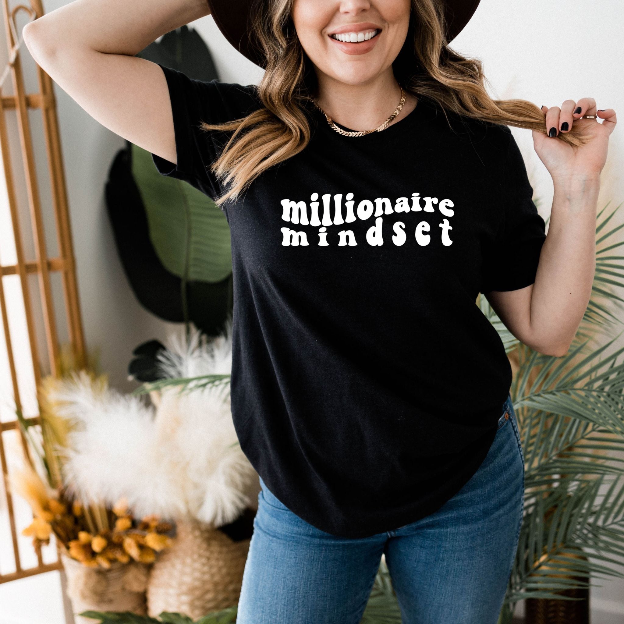 A stylish black t-shirt with the text 'Millionaire Mindset' printed on it, designed for women who aspire for success.