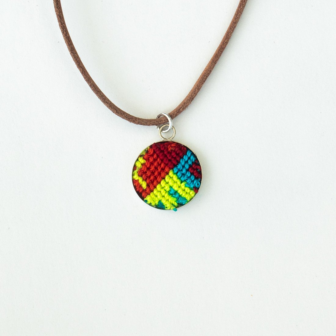 Mini Circle Friendship Necklace featuring a colorful textile pendant and leather string, handcrafted using traditional Chamula weaving techniques.