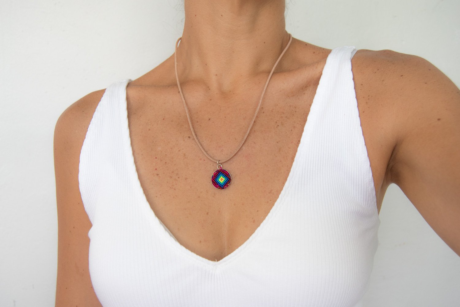 Mini Circle Friendship Necklace featuring a colorful textile pendant and leather string, handcrafted using traditional Chamula weaving techniques.