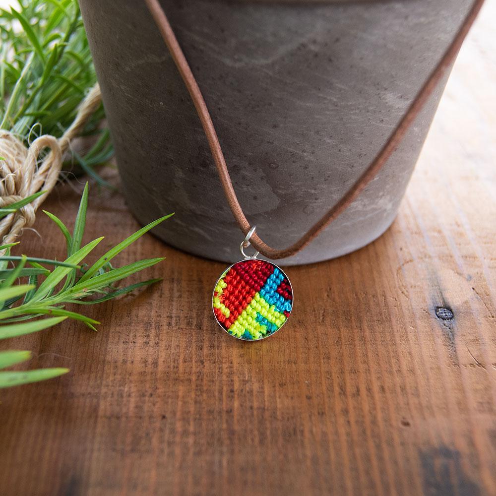 Mini Circle Friendship Necklace featuring a colorful textile pendant and leather string, handcrafted using traditional Chamula weaving techniques.