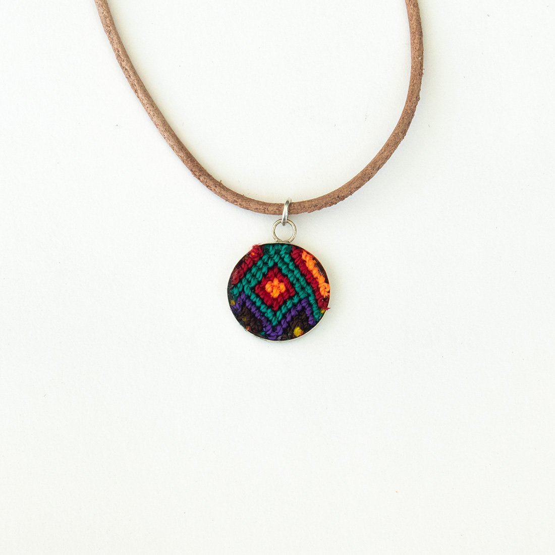 Mini Circle Friendship Necklace featuring a colorful textile pendant and leather string, handcrafted using traditional Chamula weaving techniques.