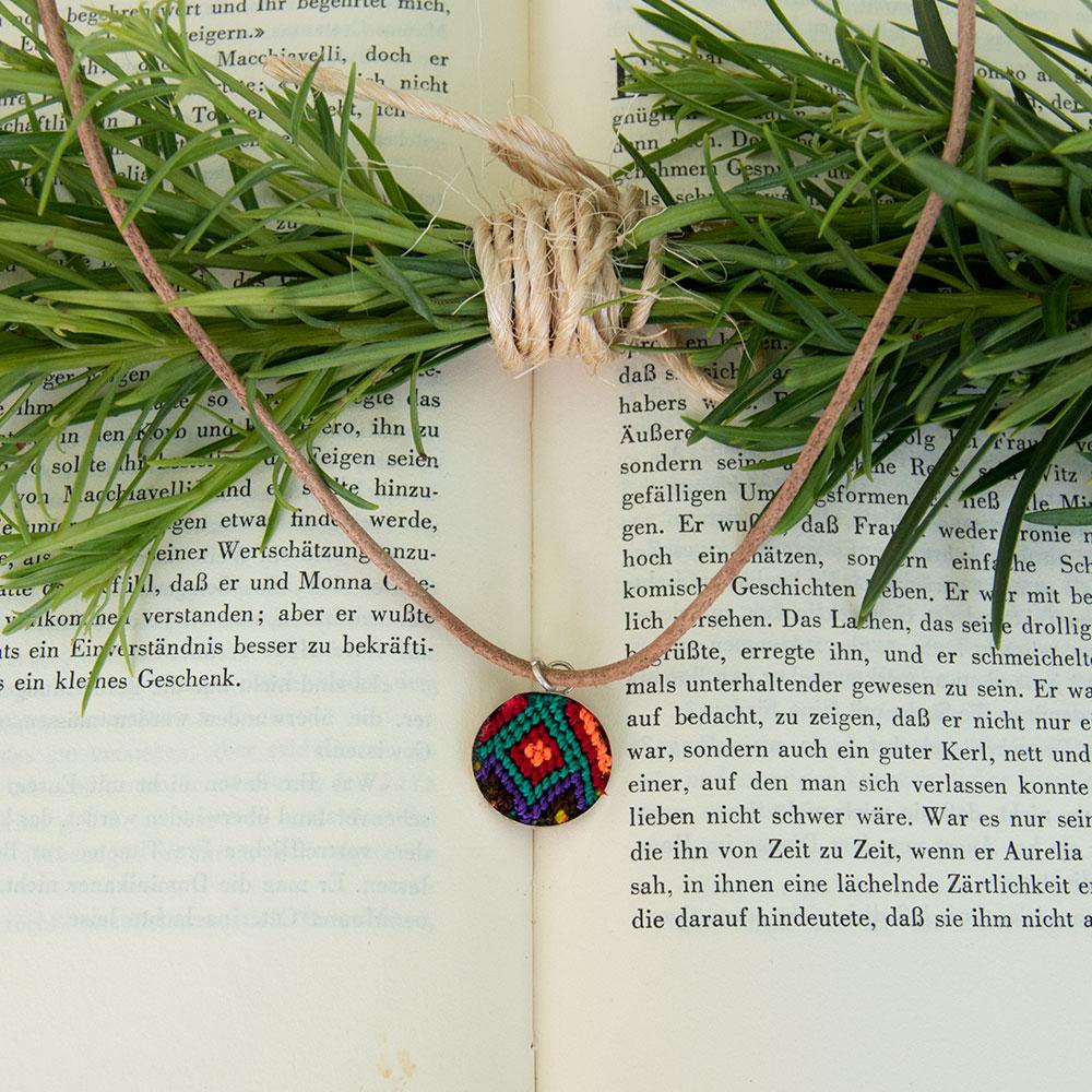 Mini Circle Friendship Necklace featuring a colorful textile pendant and leather string, handcrafted using traditional Chamula weaving techniques.