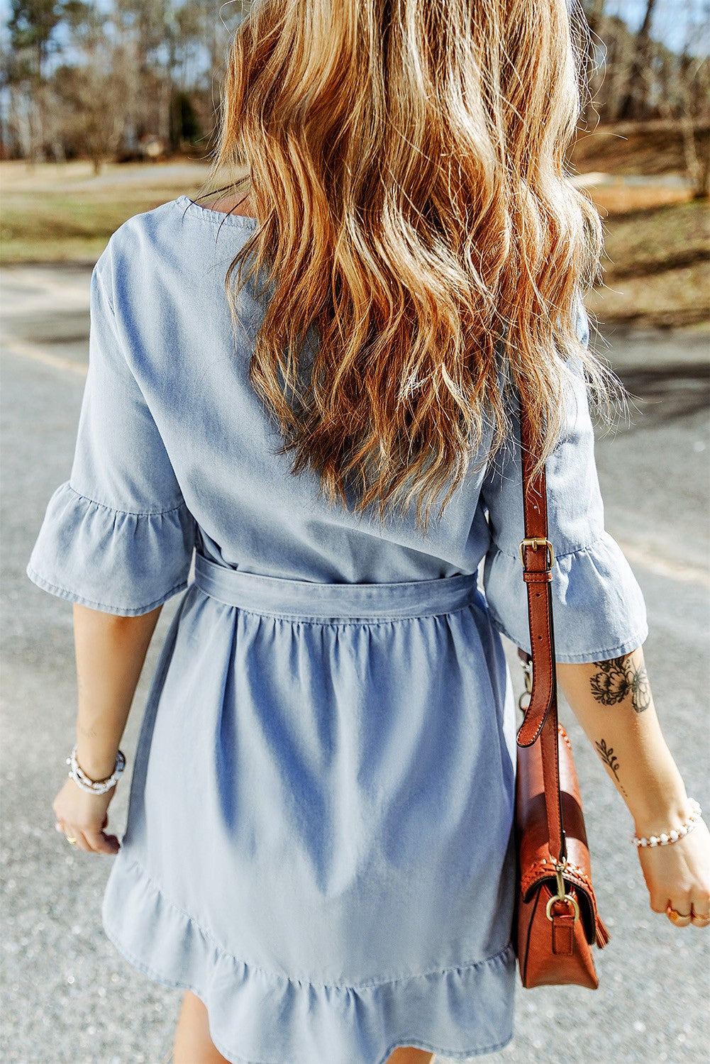 Light blue mini denim dress with ruffles, featuring a scoop neckline, 3/4 sleeves, and a decorative belt.