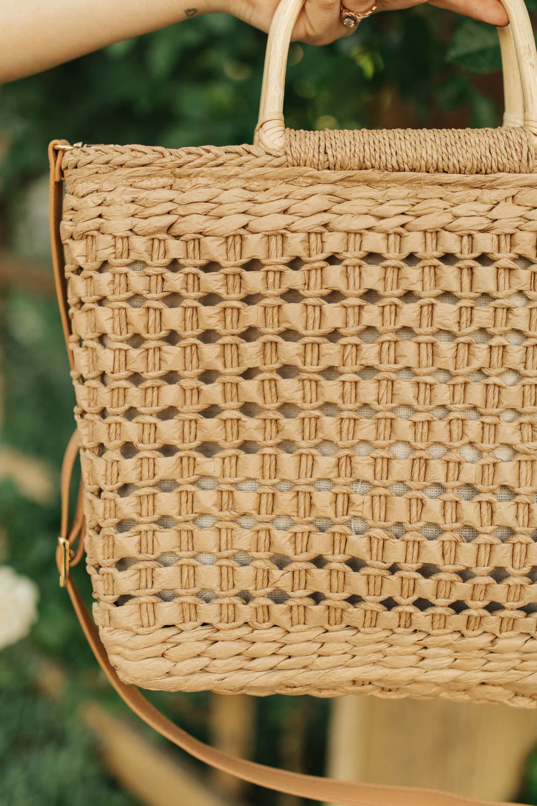 A stylish Mini Market Tote bag with a woven design, wooden handle, and adjustable strap, perfect for beach outings.