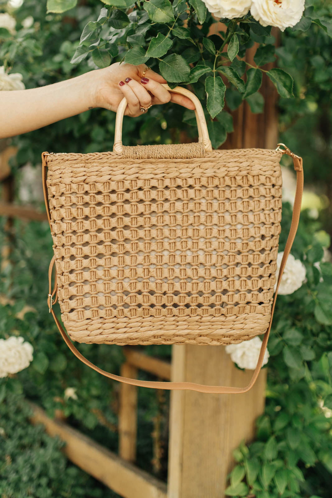 A stylish Mini Market Tote bag with a woven design, wooden handle, and adjustable strap, perfect for beach outings.