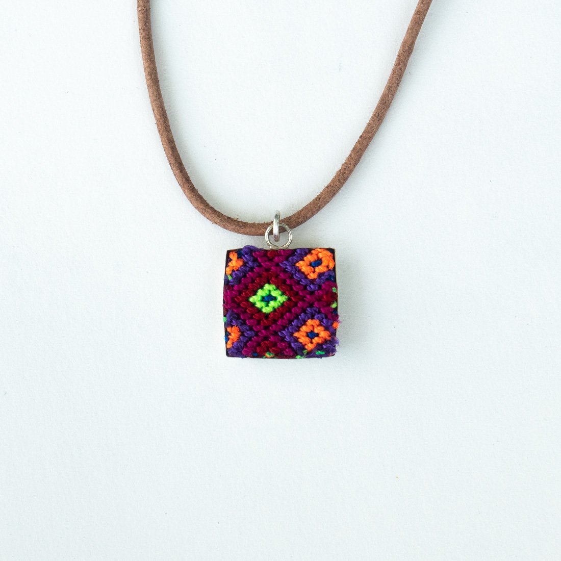 Mini Square Textile Necklace featuring a colorful woven pendant on a leather string, showcasing unique Chamula weaving from Mexico.