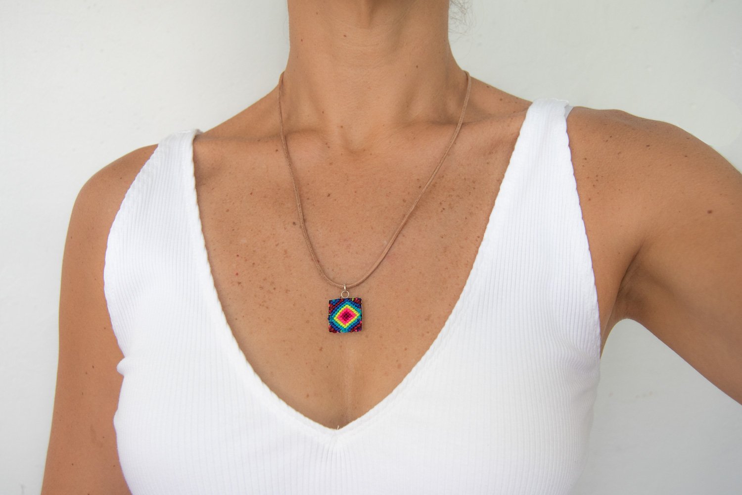 Mini Square Textile Necklace featuring a colorful woven pendant on a leather string, showcasing unique Chamula weaving from Mexico.