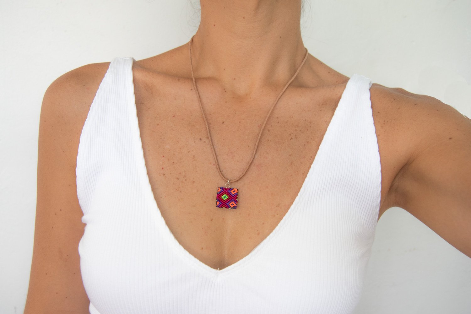 Mini Square Textile Necklace featuring a colorful woven pendant on a leather string, showcasing unique Chamula weaving from Mexico.