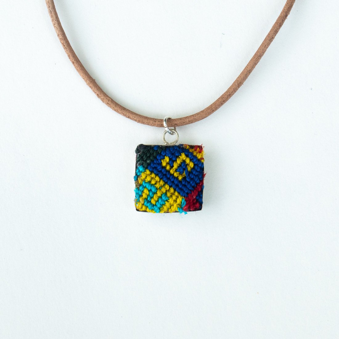 Mini Square Textile Necklace featuring a colorful woven pendant on a leather string, showcasing unique Chamula weaving from Mexico.