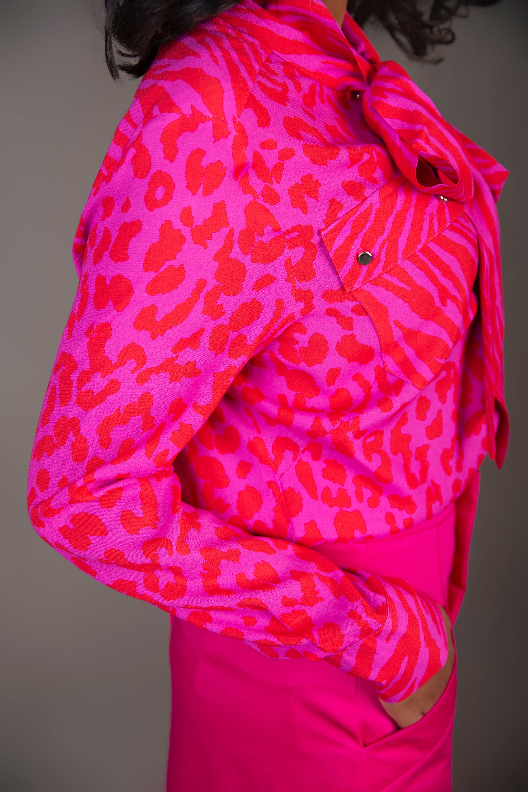 Stylish pink blouse featuring leopard and tiger prints with a tie front design, perfect for casual chic outfits.