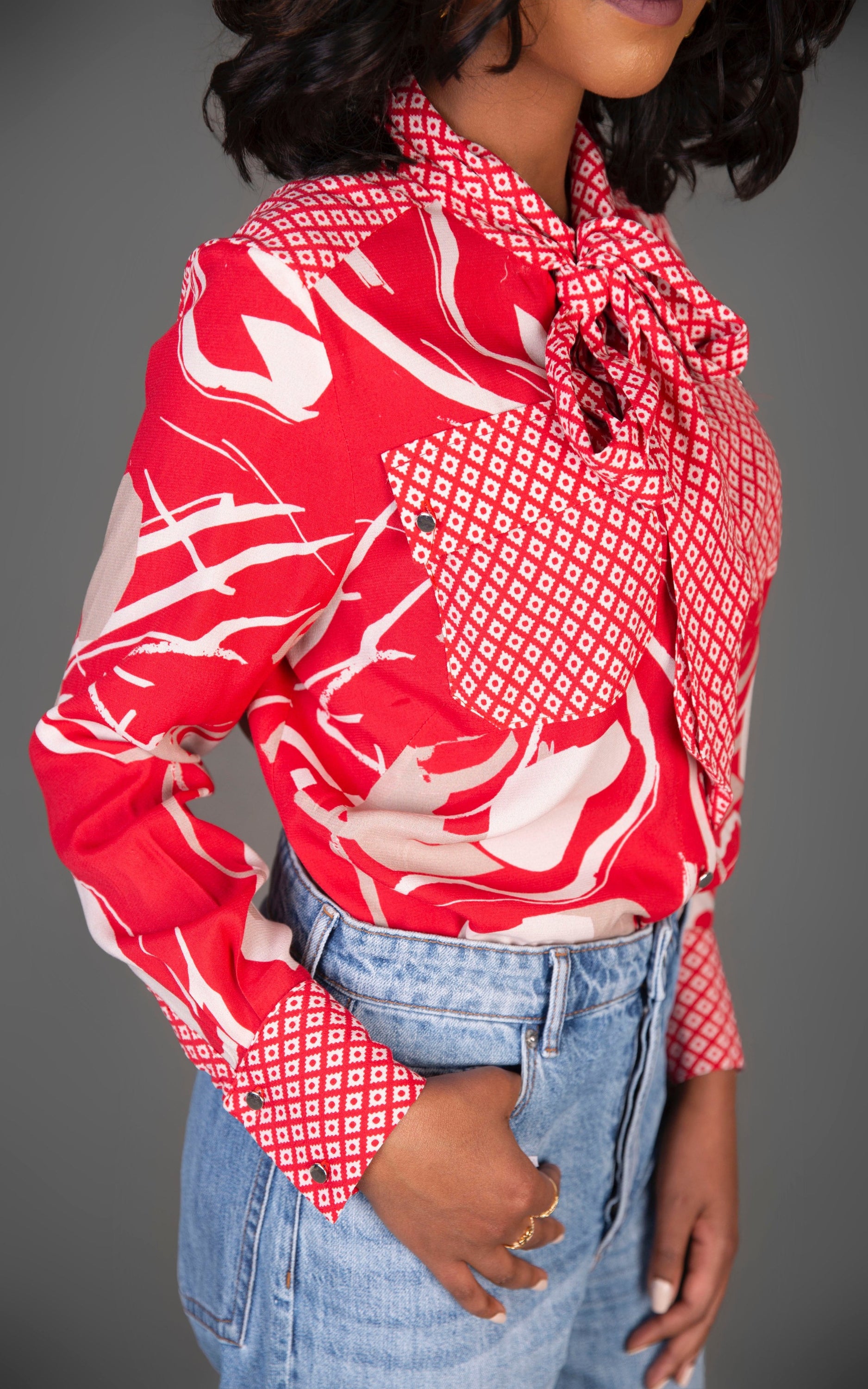 A vibrant red mixed print blouse featuring a stylish tie front design, perfect for casual and smart occasions.