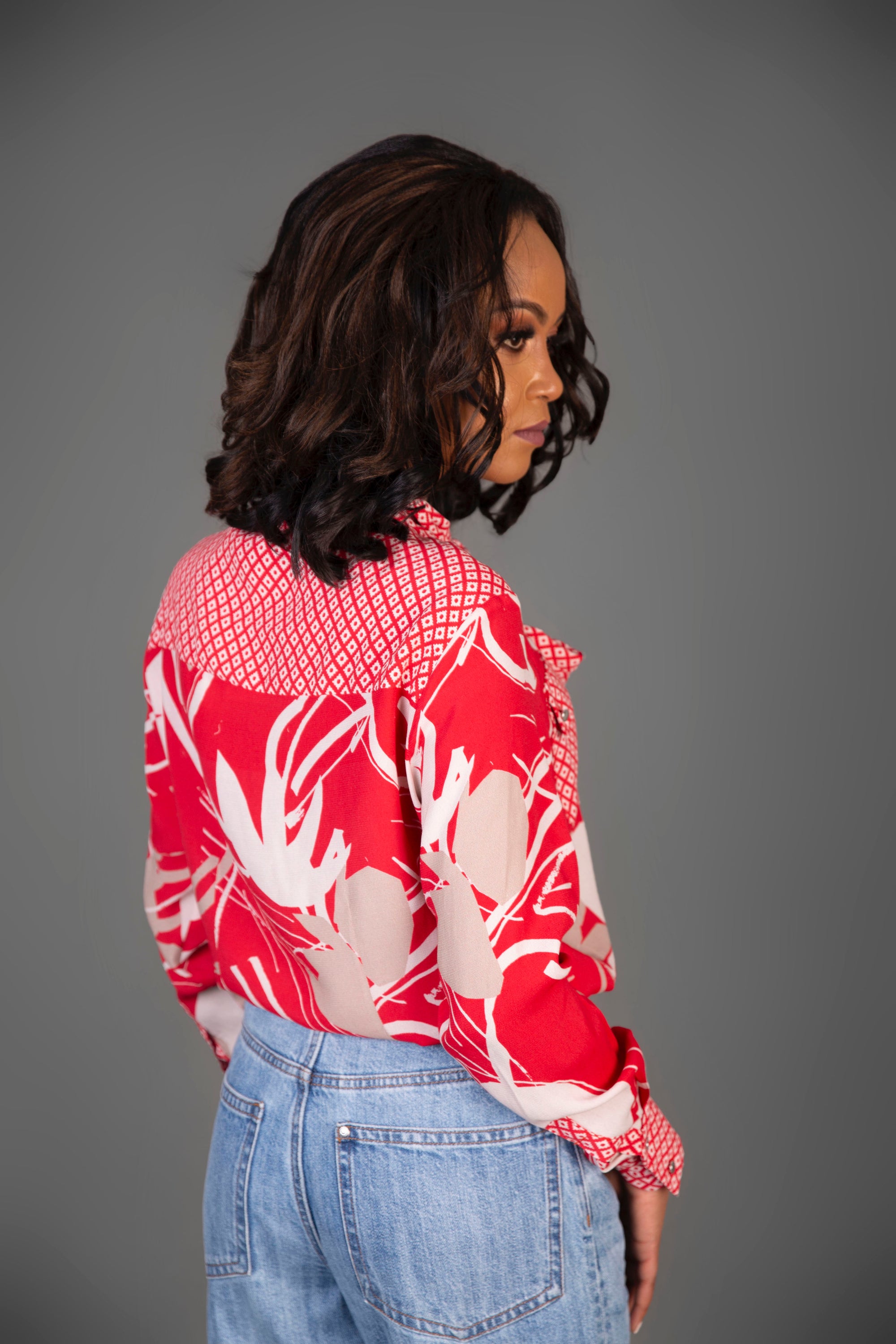 A vibrant red mixed print blouse featuring a stylish tie front design, perfect for casual and smart occasions.