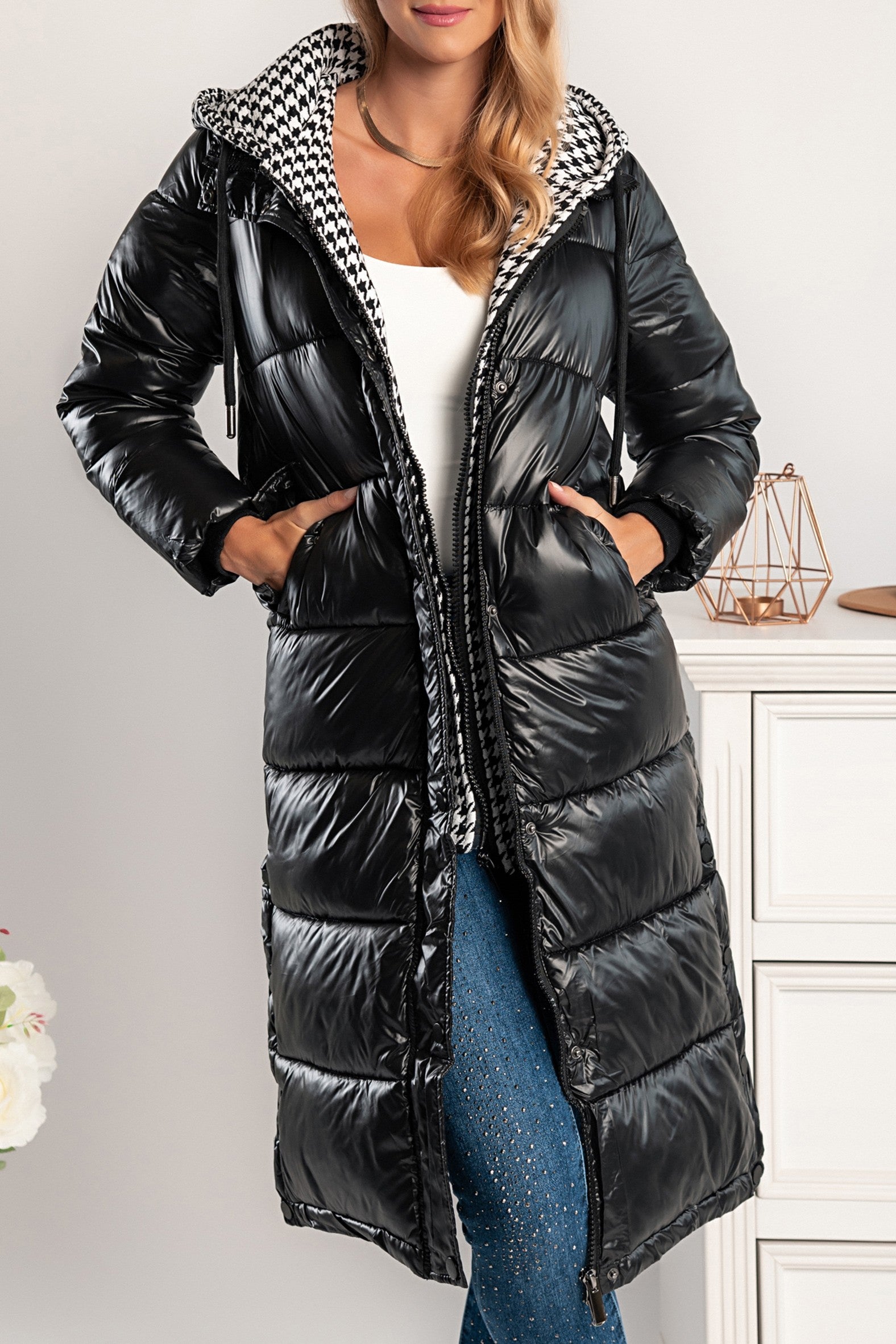 Moena long quilted jacket in black with detachable hood and pepita pattern, featuring two front pockets and double zipper fastening.