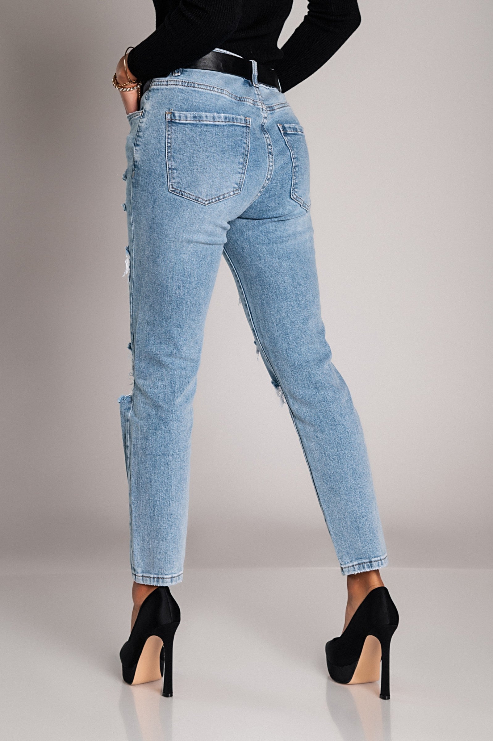 Light blue Mom fit jeans with rips, featuring a straight cut, button and zipper closure, and front and back pockets.