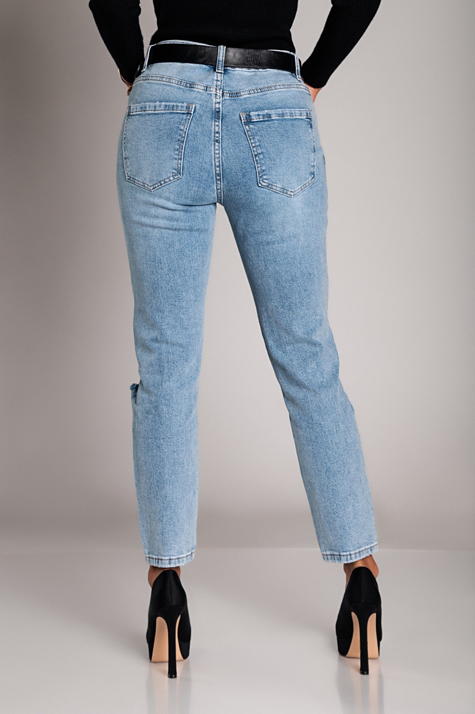 Light blue Mom fit jeans with rips, featuring a straight cut, button and zipper closure, and front and back pockets.