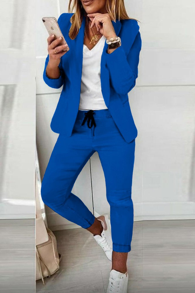 Monochrome elegant trousers and blazer set Estrena in blue, featuring a classic collar, long sleeves, and slim fit trousers with a drawstring waist.