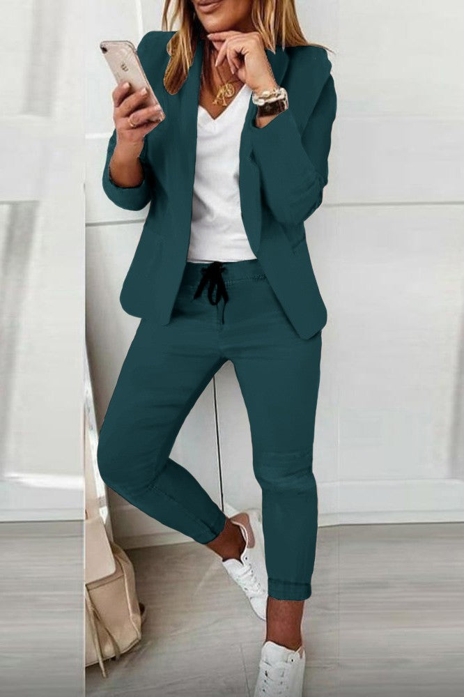 Monochrome elegant trousers and blazer set in petrol color, featuring a classic collar, long sleeves, and slim fit trousers with a drawstring waist.