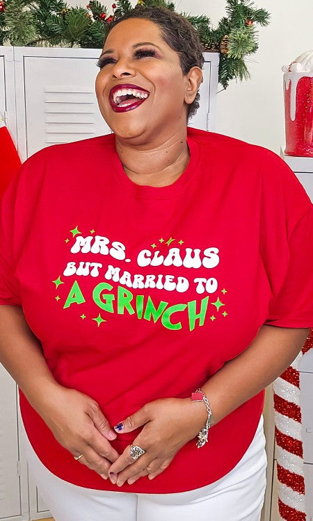 Mrs. Claus But Married to A Grinch Graphic T-Shirt in vibrant red with green sparkles, showcasing a fun Christmas design.