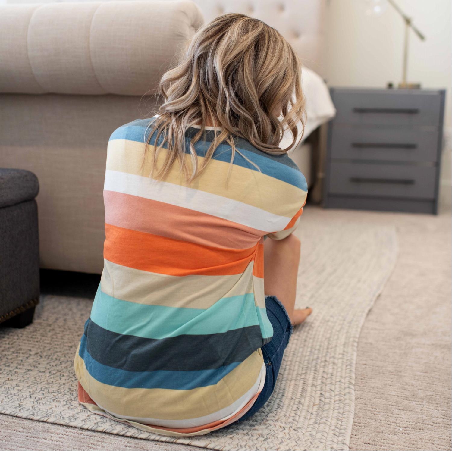 A vibrant multi-color striped short sleeve top with a trendy front tie, showcasing its stylish design and soft fabric.