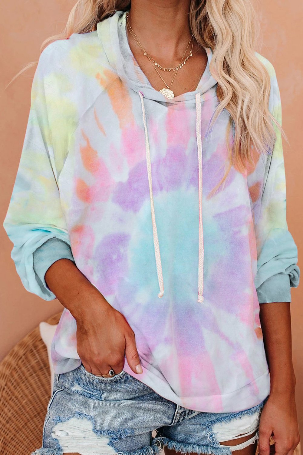 A stylish multicolor tie-dye knit hoodie displayed on a mannequin, showcasing its vibrant colors and relaxed fit.