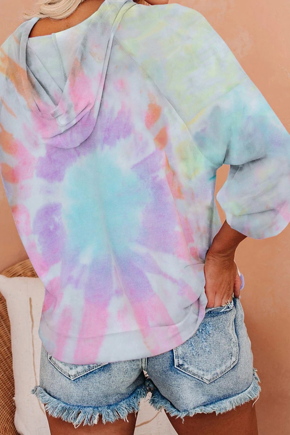 A stylish multicolor tie-dye knit hoodie displayed on a mannequin, showcasing its vibrant colors and relaxed fit.