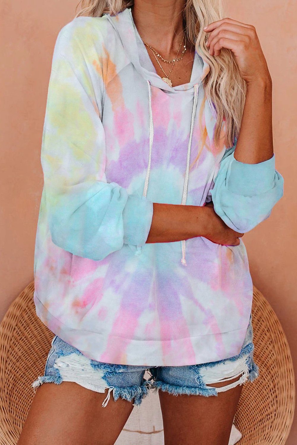 A stylish multicolor tie-dye knit hoodie displayed on a mannequin, showcasing its vibrant colors and relaxed fit.