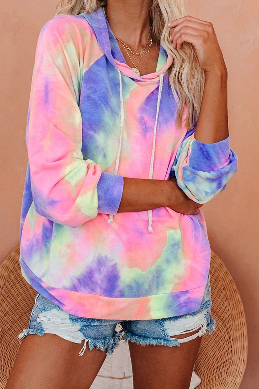 A stylish multicolor tie-dye knit hoodie displayed on a mannequin, showcasing its vibrant colors and relaxed fit.