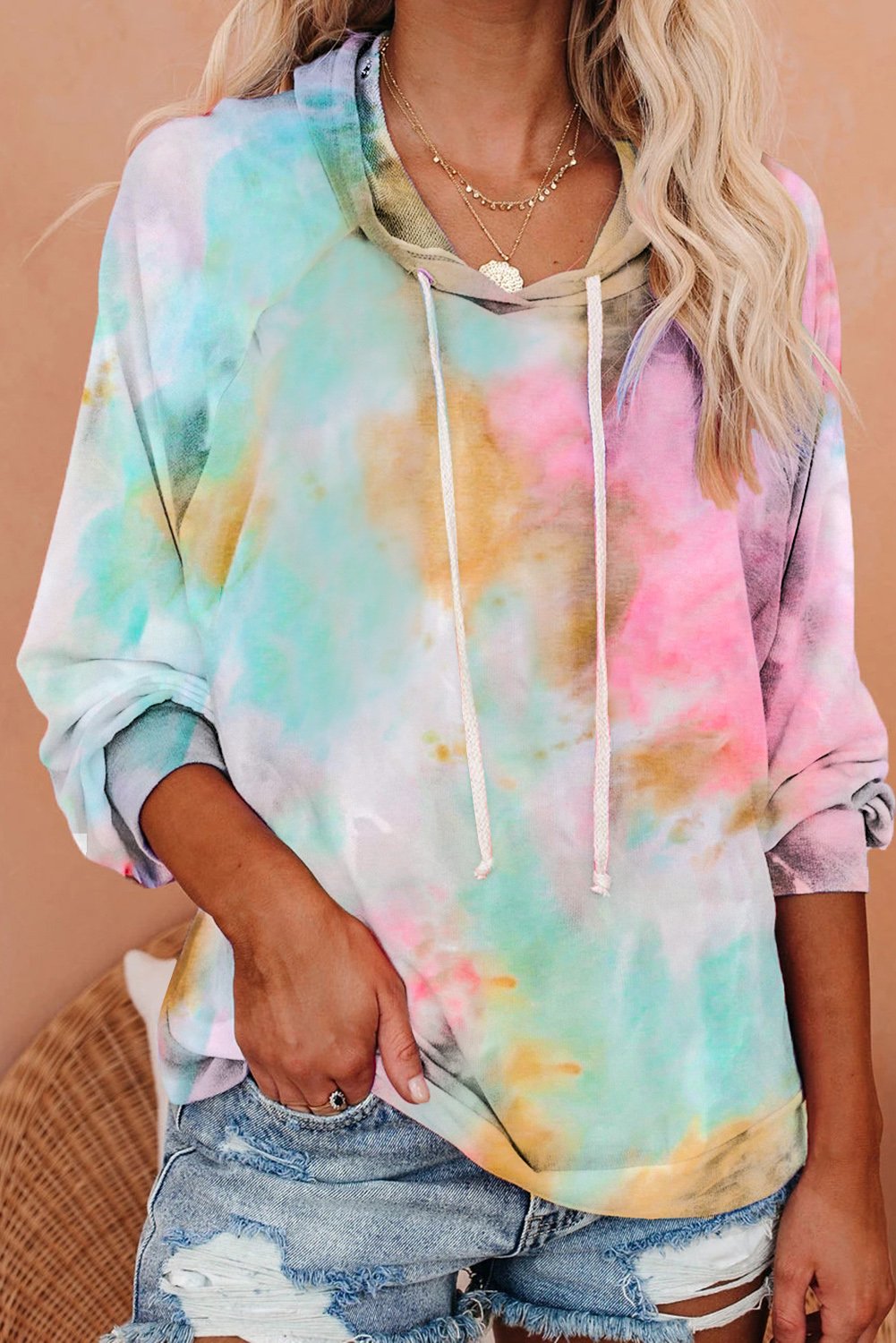 A stylish multicolor tie-dye knit hoodie displayed on a mannequin, showcasing its vibrant colors and relaxed fit.