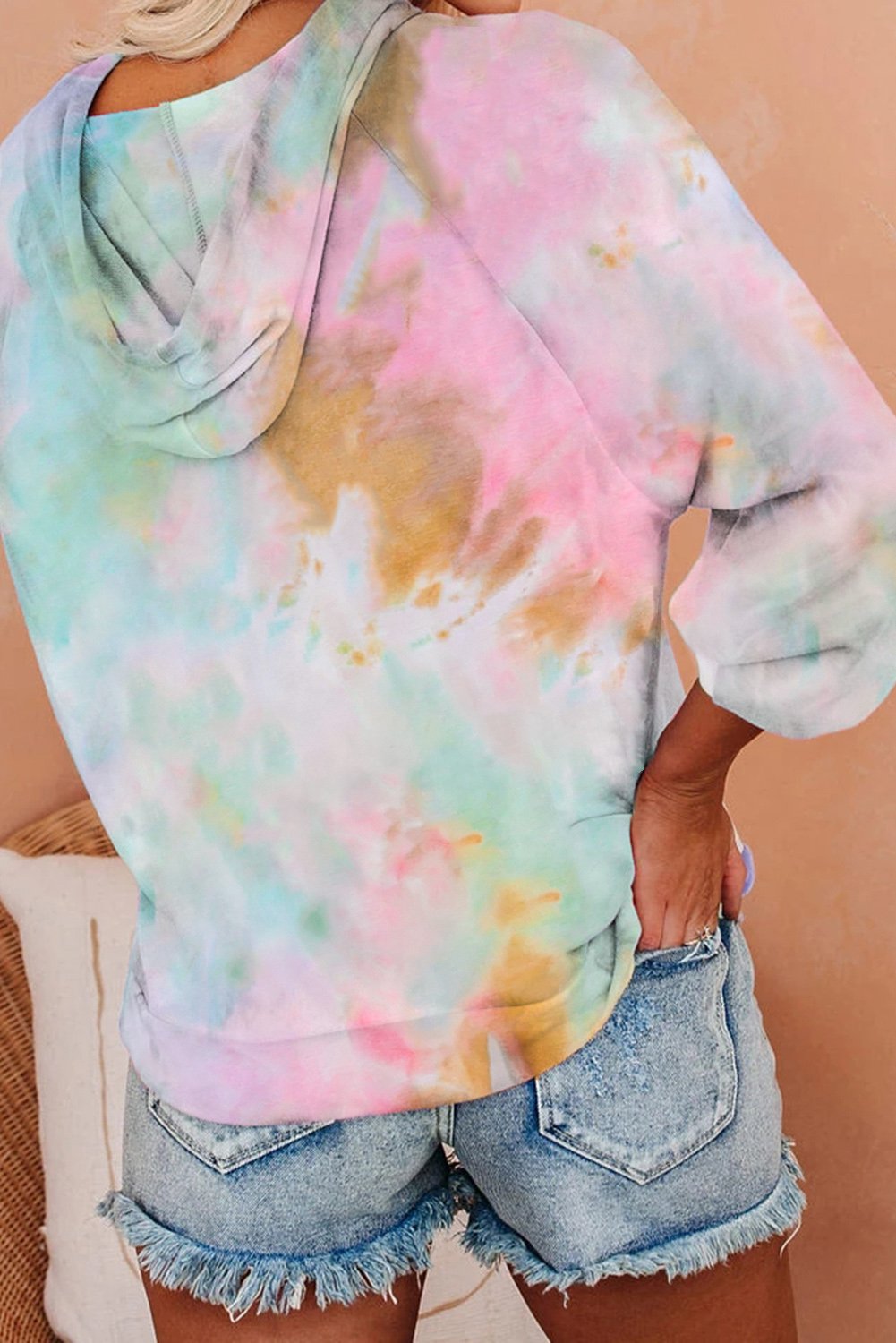 A stylish multicolor tie-dye knit hoodie displayed on a mannequin, showcasing its vibrant colors and relaxed fit.