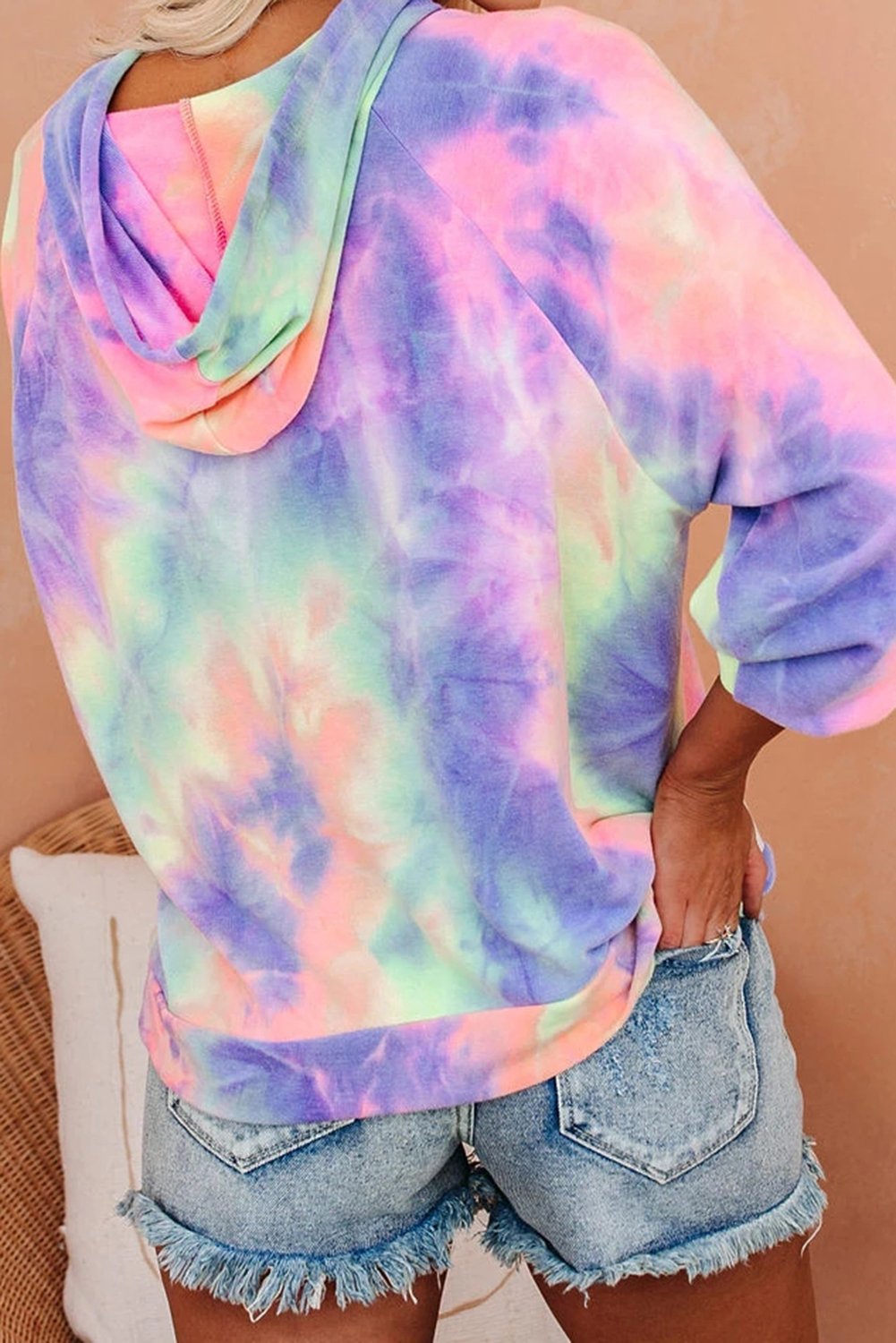 A stylish multicolor tie-dye knit hoodie displayed on a mannequin, showcasing its vibrant colors and relaxed fit.