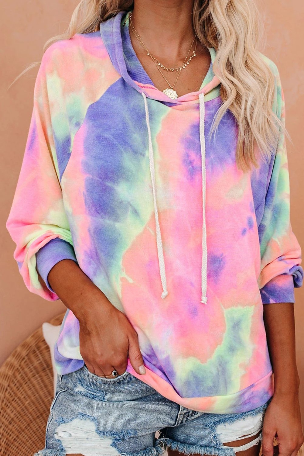 A stylish multicolor tie-dye knit hoodie displayed on a mannequin, showcasing its vibrant colors and relaxed fit.