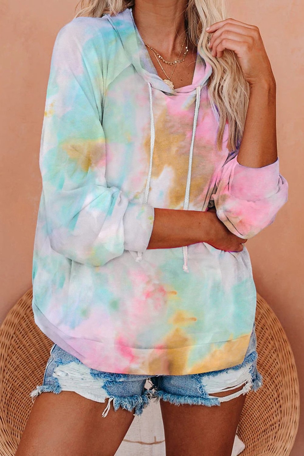 A stylish multicolor tie-dye knit hoodie displayed on a mannequin, showcasing its vibrant colors and relaxed fit.