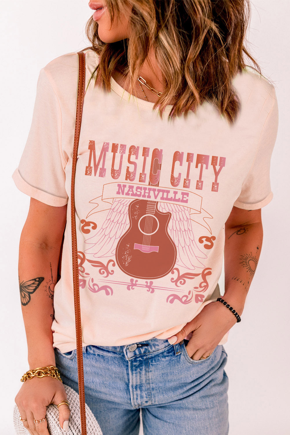 MUSIC CITY Cuffed Short Sleeve Tee featuring a chic graphic design, round neck, and short sleeves, made from a comfortable polyester-spandex blend.