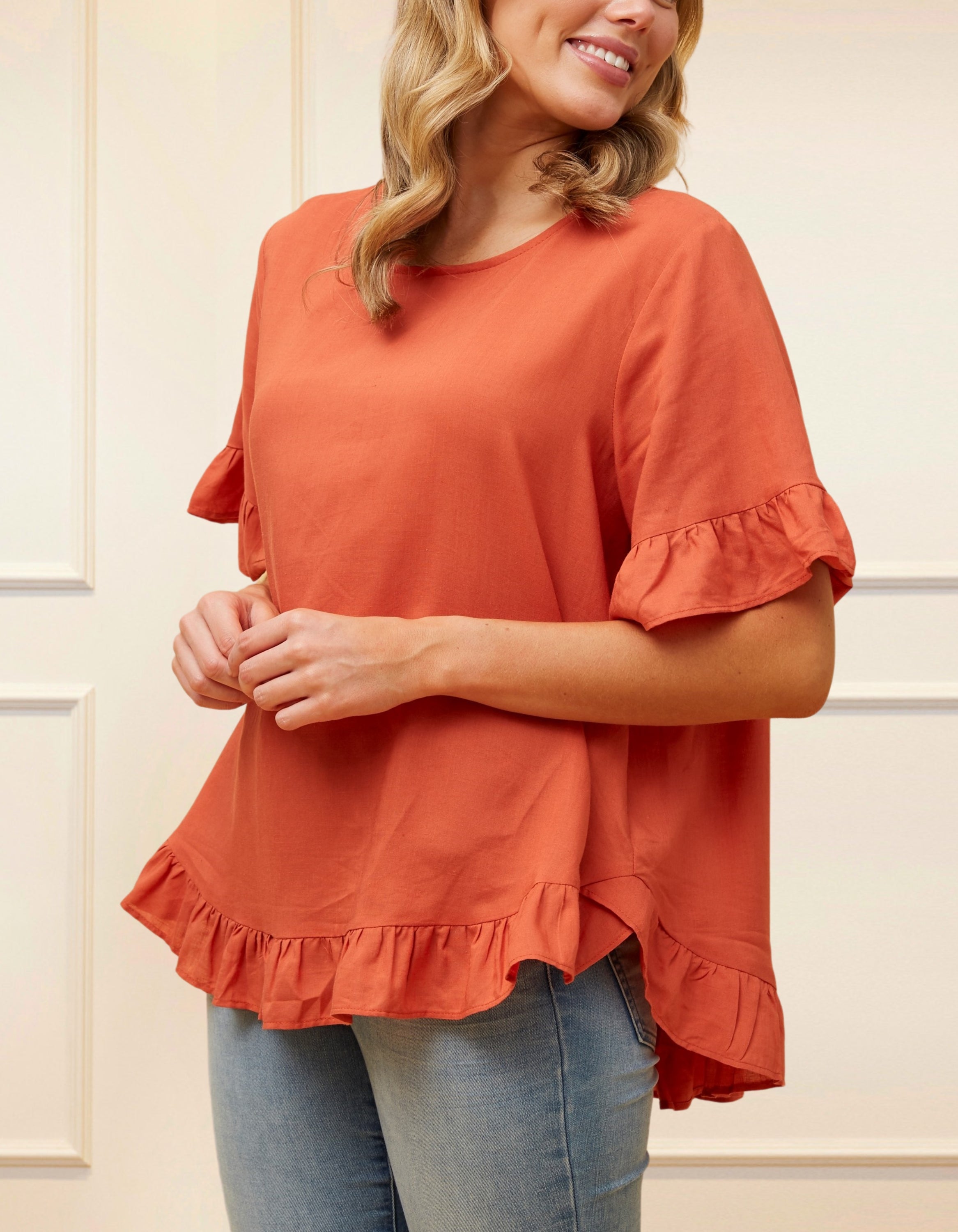 Mylene Top in a relaxed fit with frilled high-low hem, showcasing its breathable linen blend fabric and stylish design in vibrant colors.