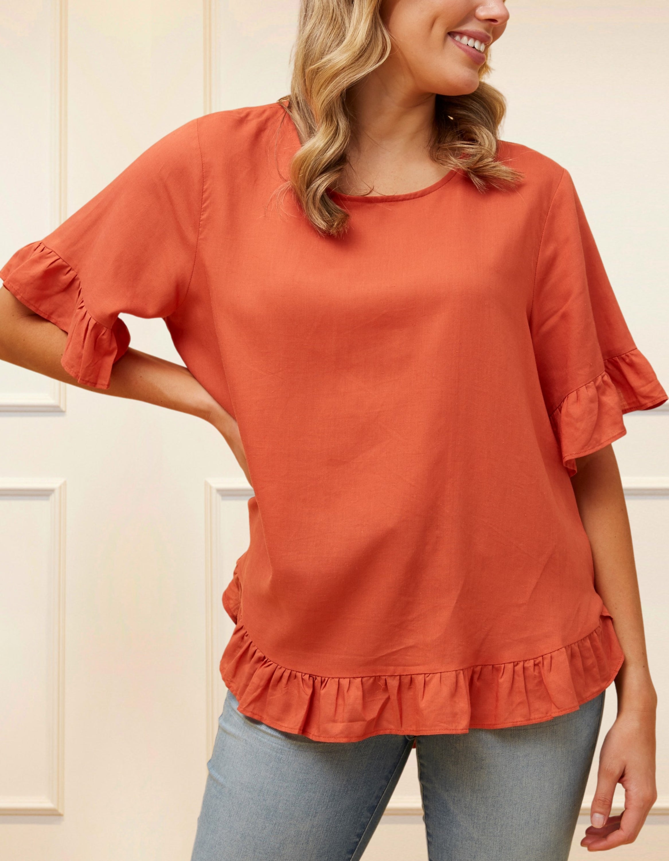 Mylene Top in a relaxed fit with frilled high-low hem, showcasing its breathable linen blend fabric and stylish design in vibrant colors.