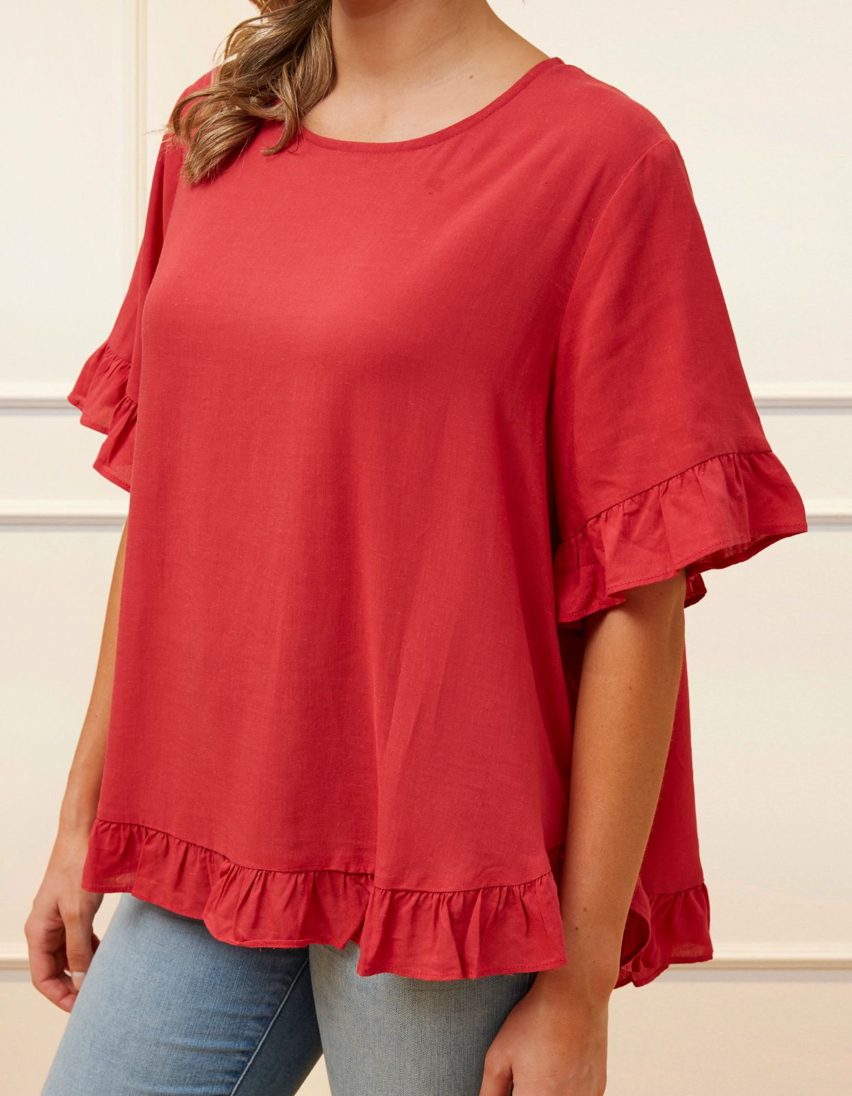 Mylene Top in a relaxed fit with frilled high-low hem, showcasing its breathable linen blend fabric and stylish design in vibrant colors.