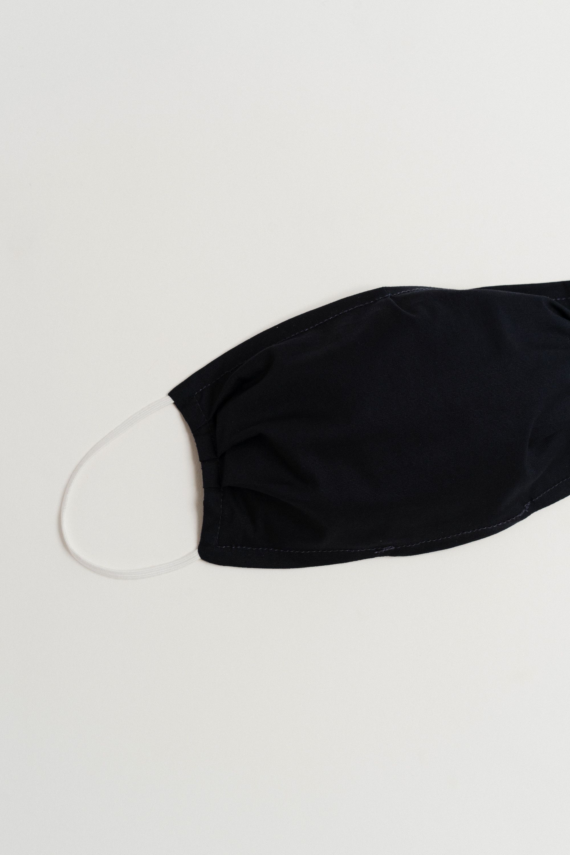 Navy face mask made of 100% cotton with pleats and filter pocket, designed for comfort and style.