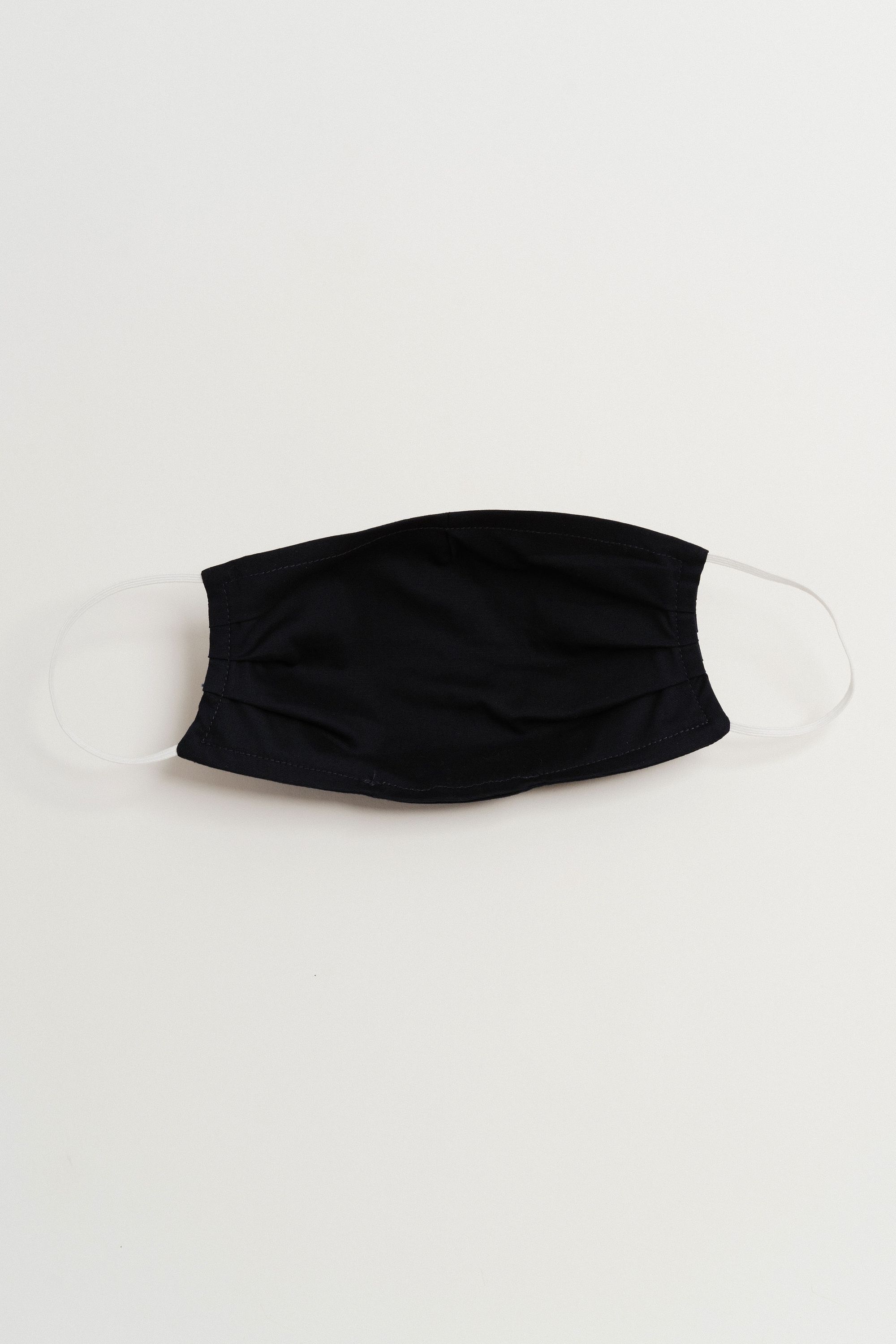 Navy face mask made of 100% cotton with pleats and filter pocket, designed for comfort and style.