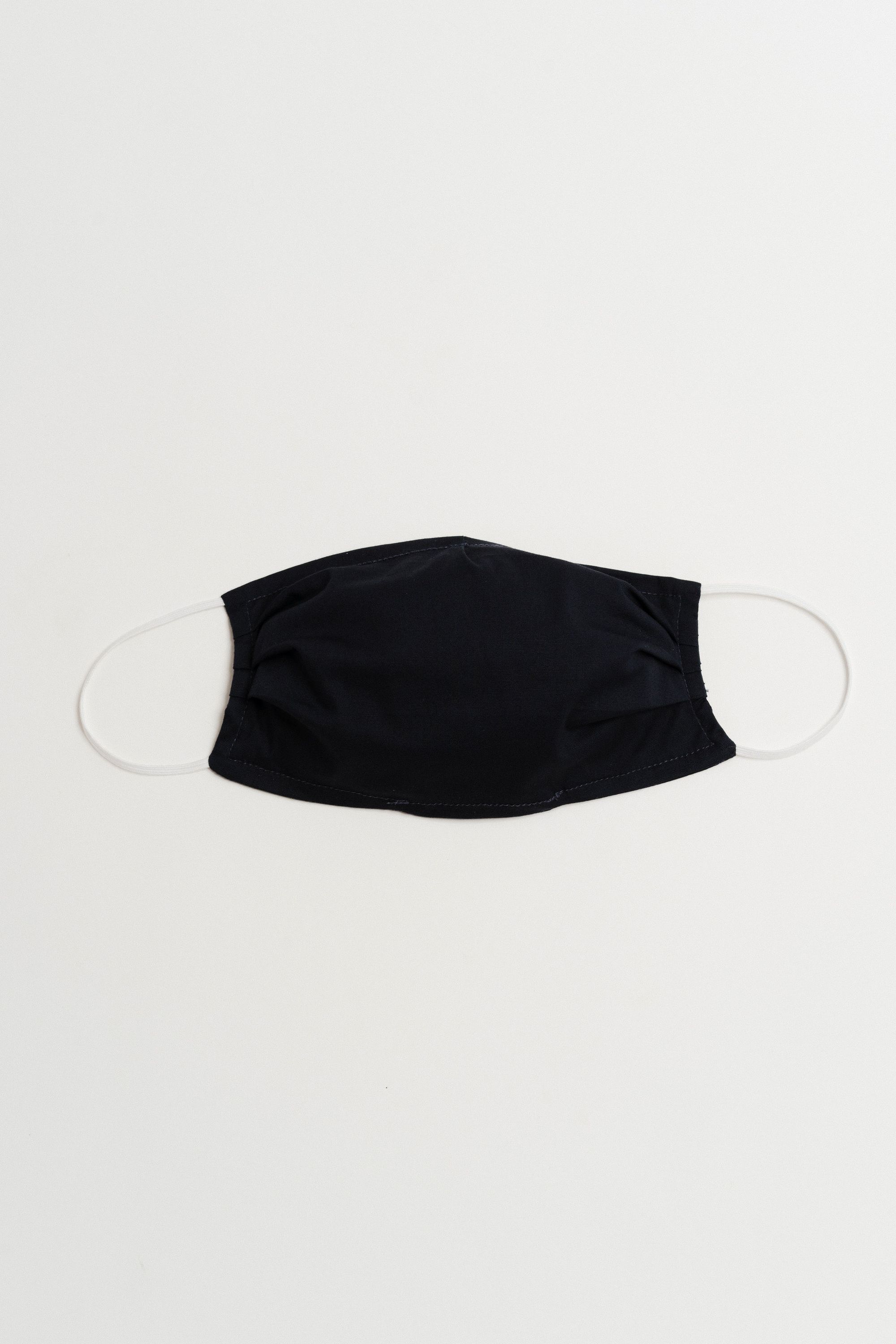 Navy face mask made of 100% cotton with pleats and filter pocket, designed for comfort and style.