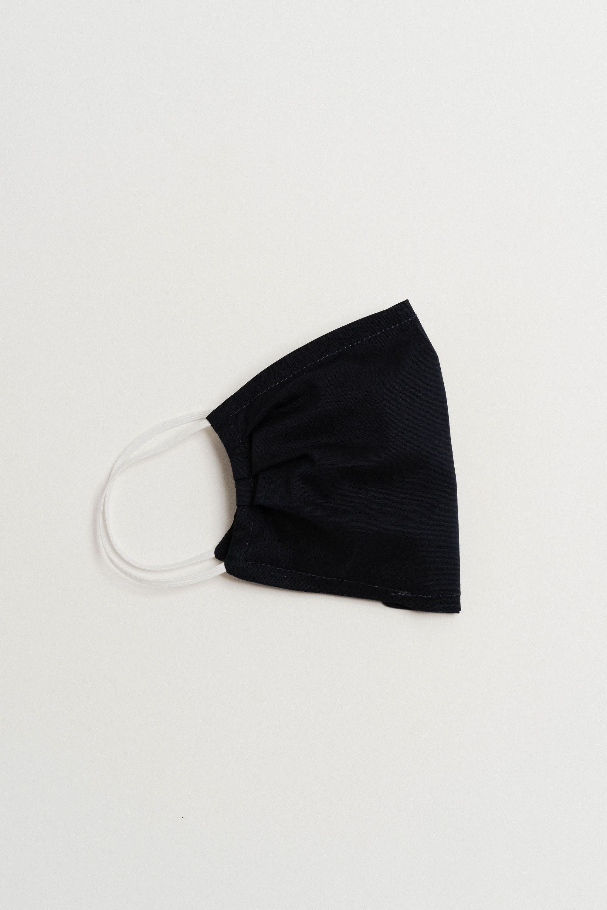 Navy face mask made of 100% cotton with pleats and filter pocket, designed for comfort and style.