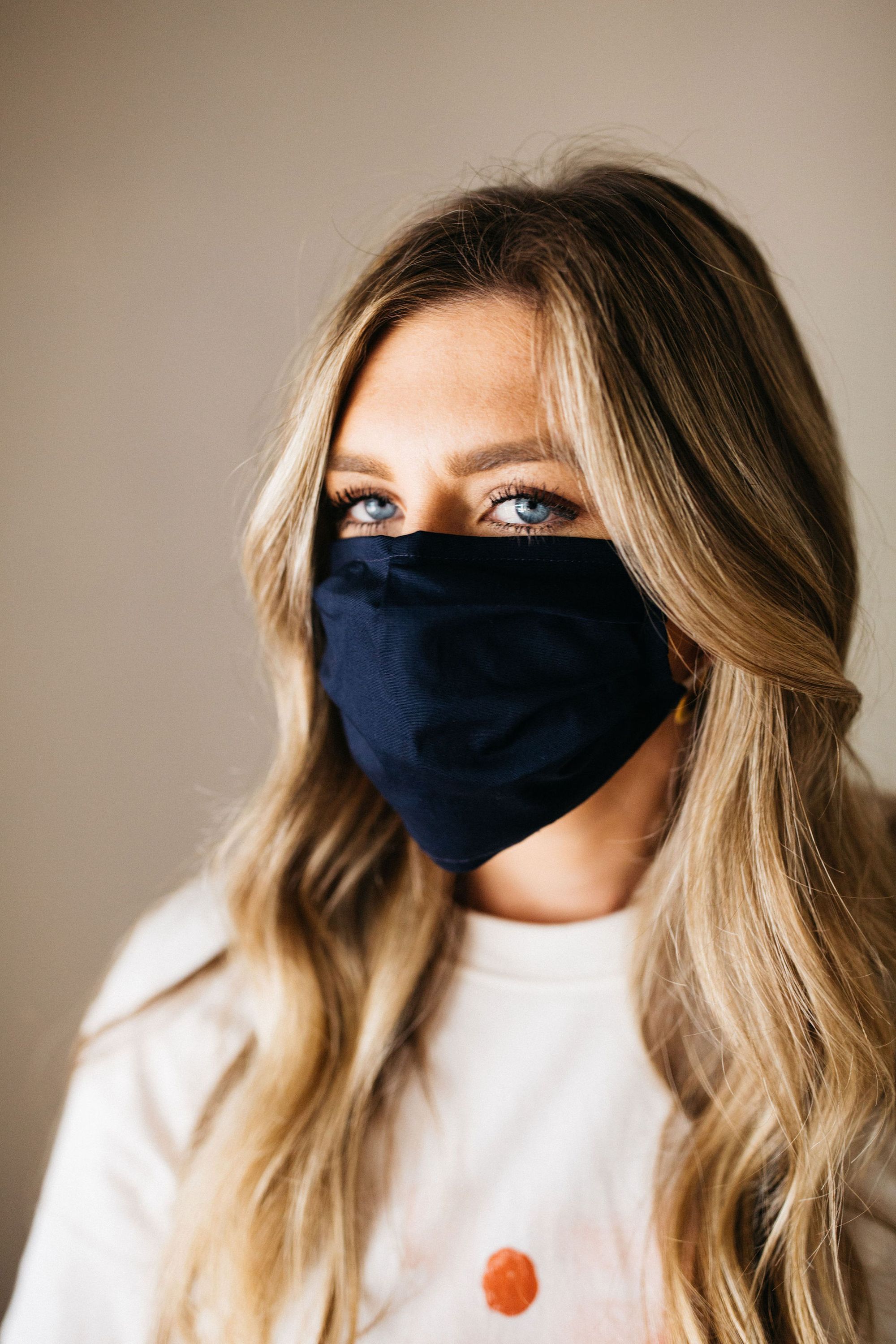 Navy face mask made of 100% cotton with pleats and filter pocket, designed for comfort and style.