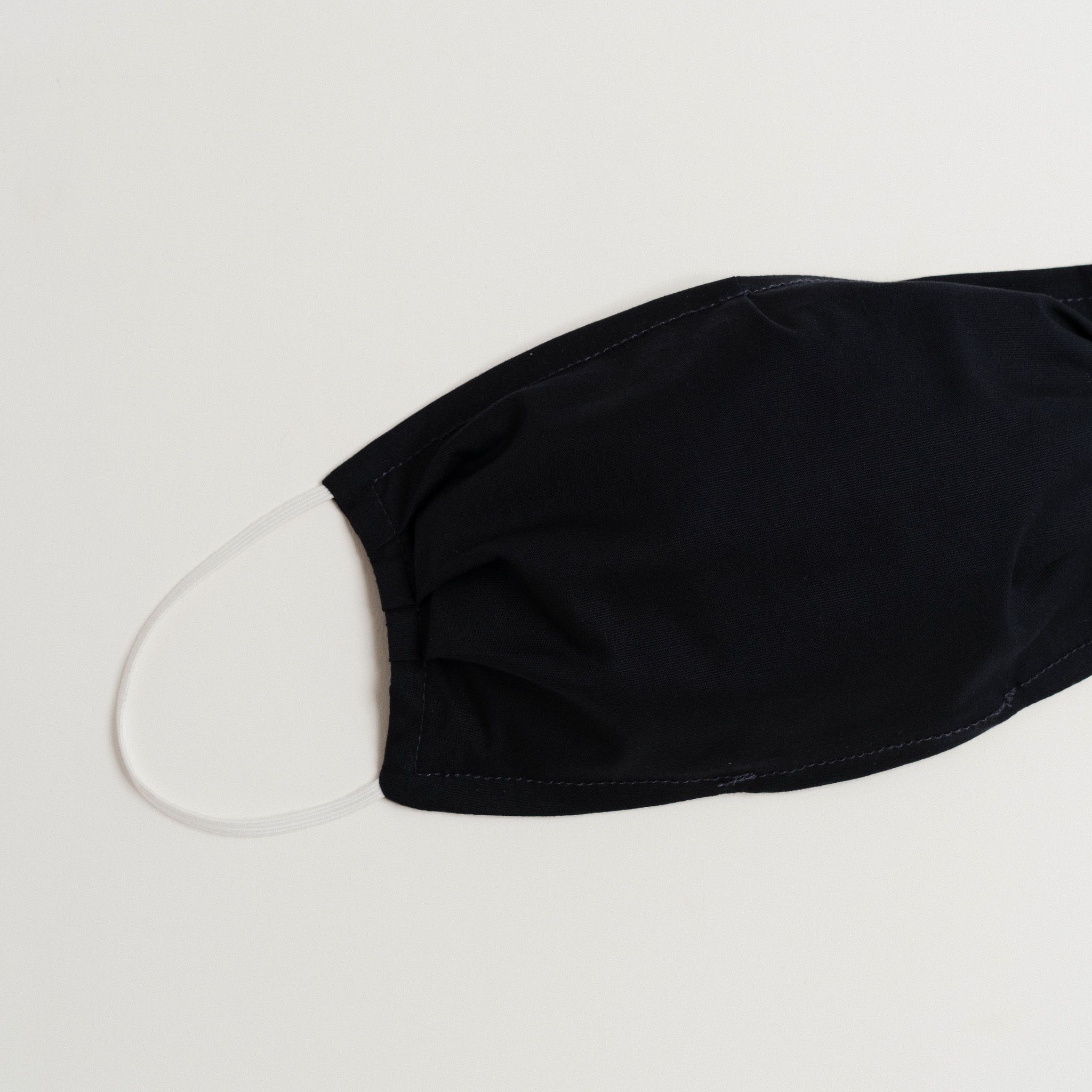 Navy face mask made of 100% cotton with pleats and filter pocket, designed for comfort and style.