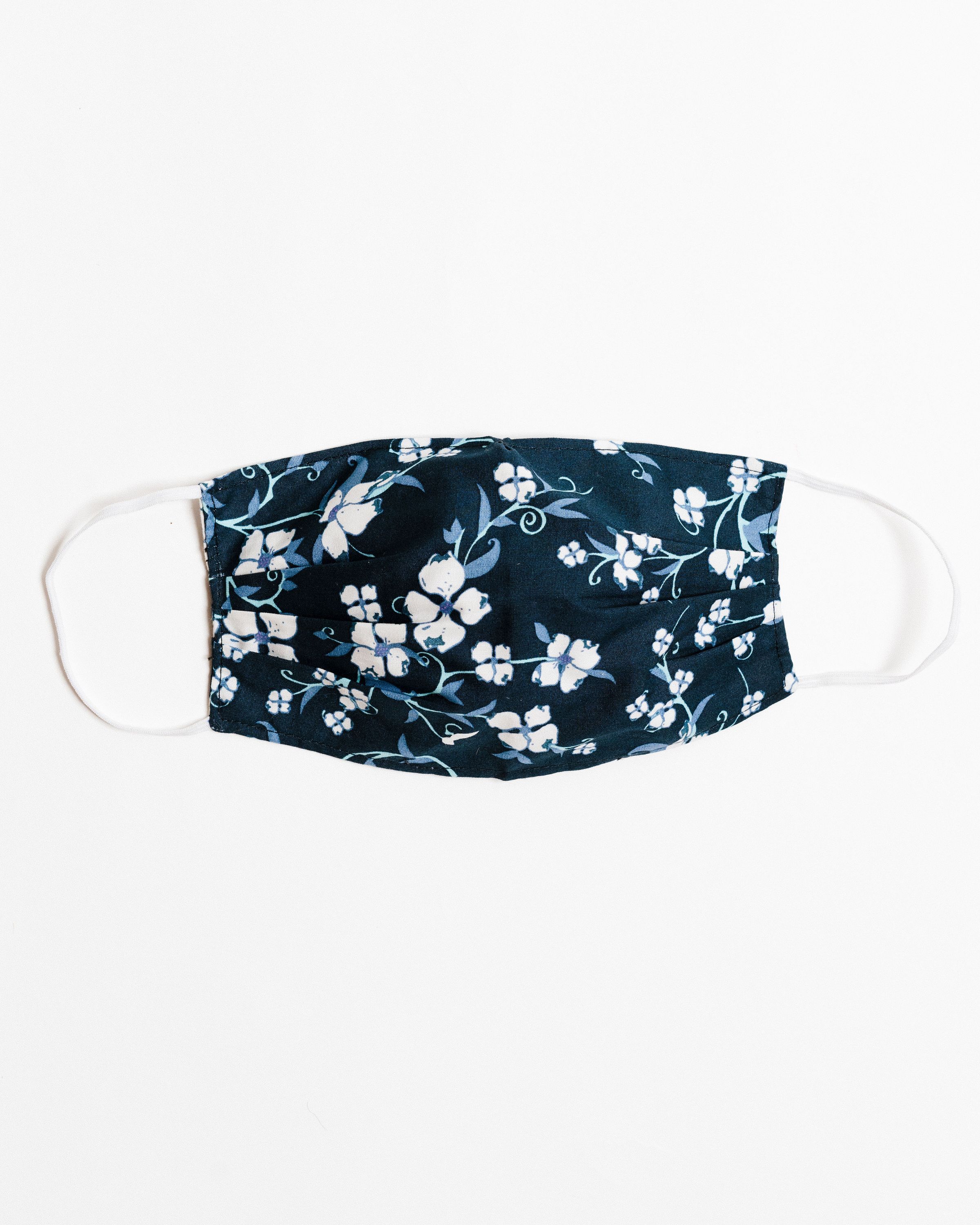 Navy floral face mask made of breathable cotton with elastic ear straps, featuring a stylish floral design.