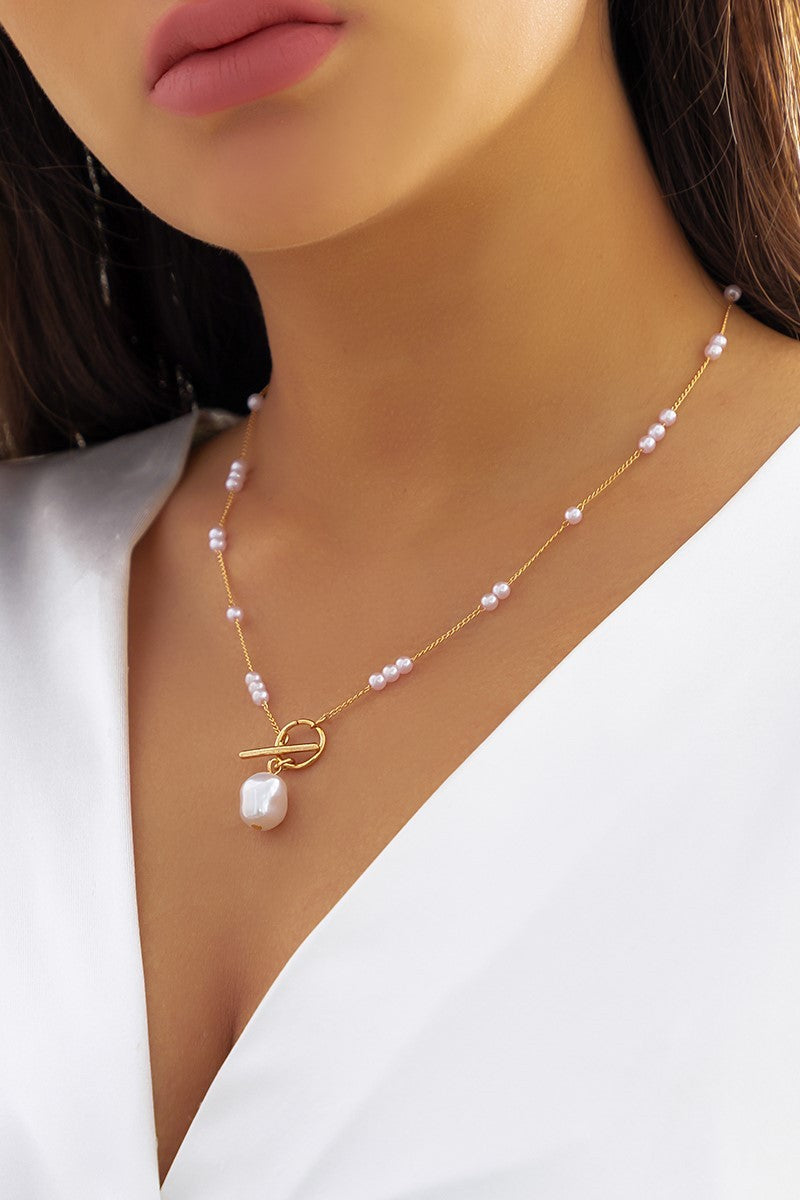 Elegant gold necklace featuring imitation pearls and a stylish pendant, showcasing a luxurious design.