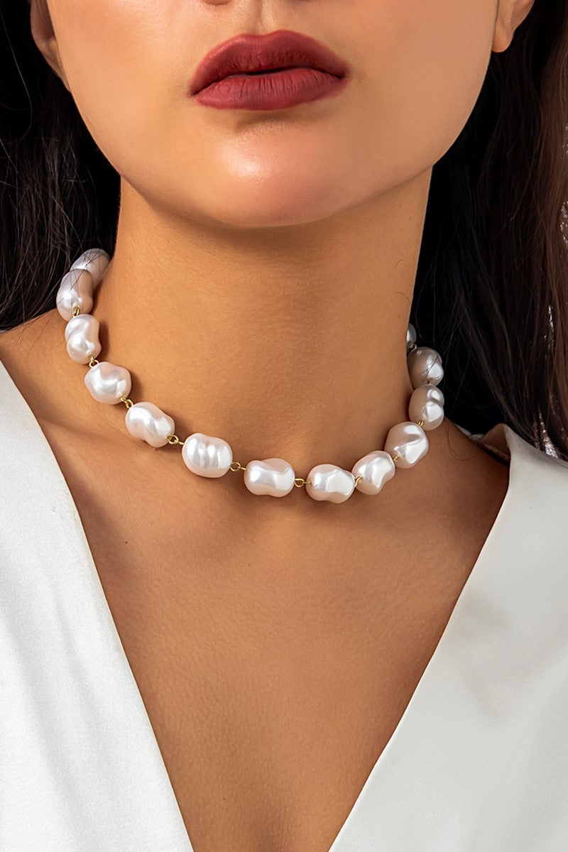 Elegant gold-colored necklace featuring oval-shaped imitation pearls, secured with a metal lobster clasp.